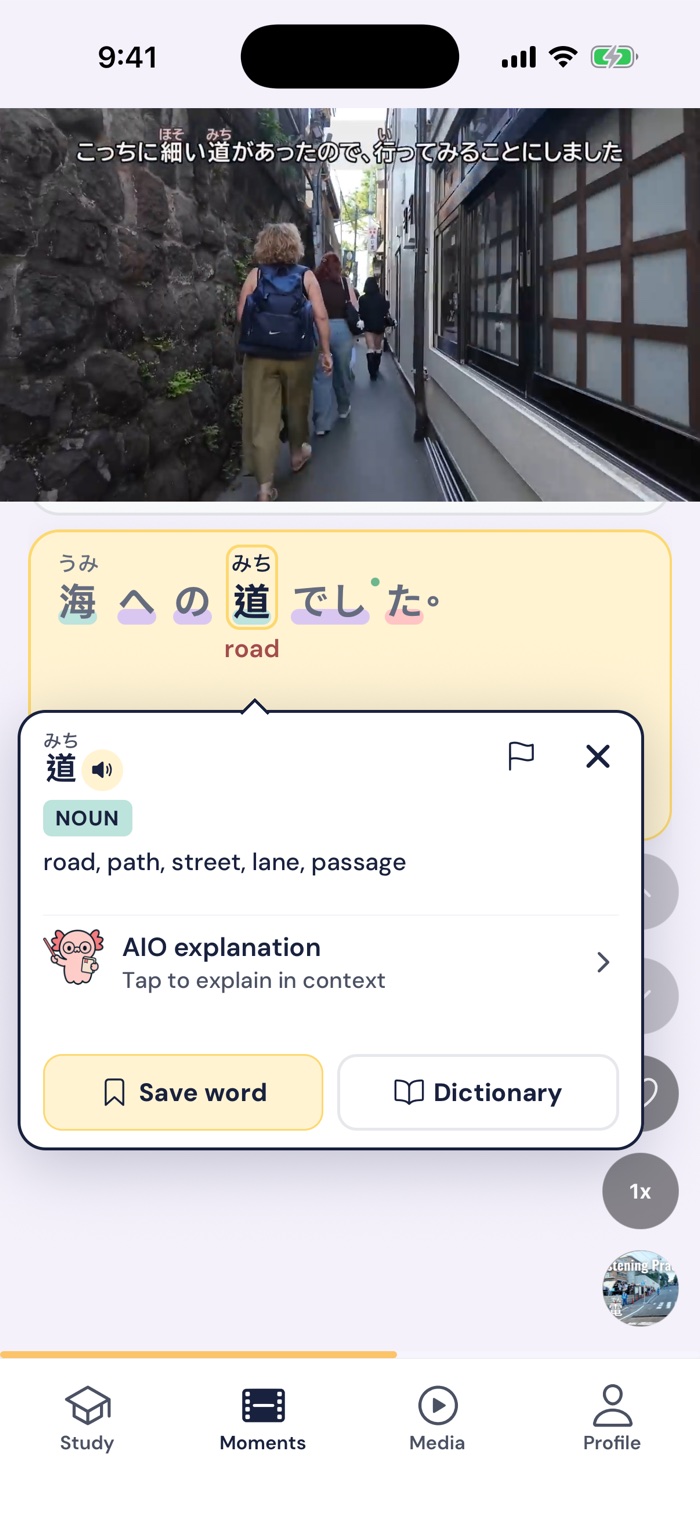 Gravity's Moments feed: a short clip of a narrow street in a seaside town, the line 海への道でした underneath, and the tapped word 道 showing its meaning and a Save word button